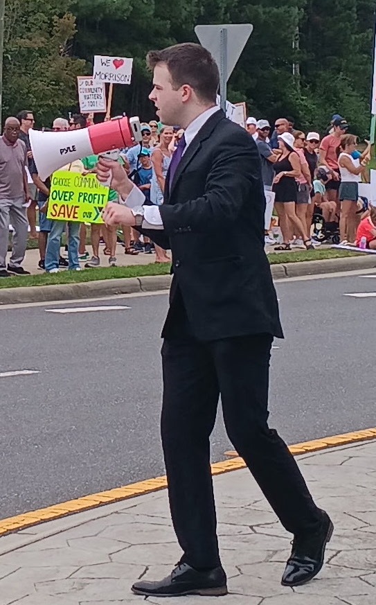 JD Hopper speaking through a megaphone at the Save Morrison YMCA rally in Ballantyne, Charlotte